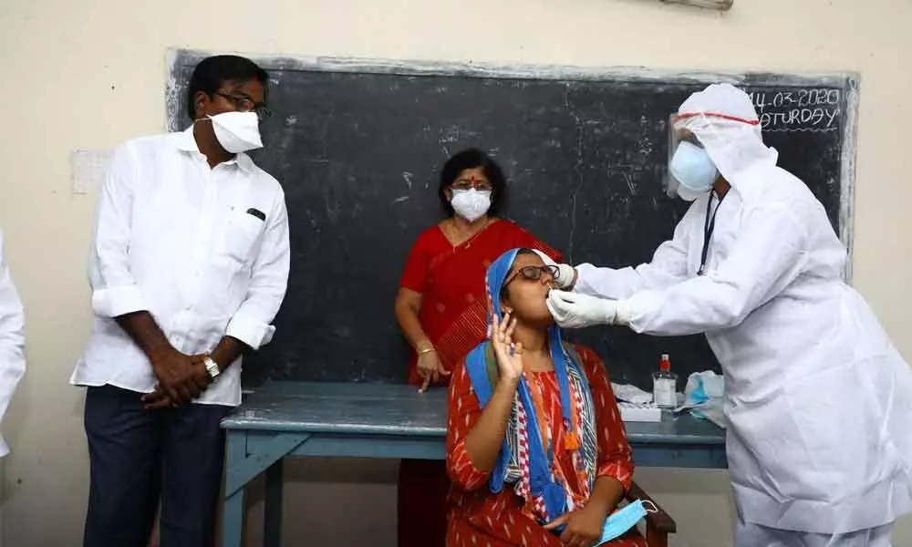 Transport Minister P Ajay Kumar observing a health staff conducting rapid antigen test to a woman at Government Women’s Degree College in Khammam on Monday