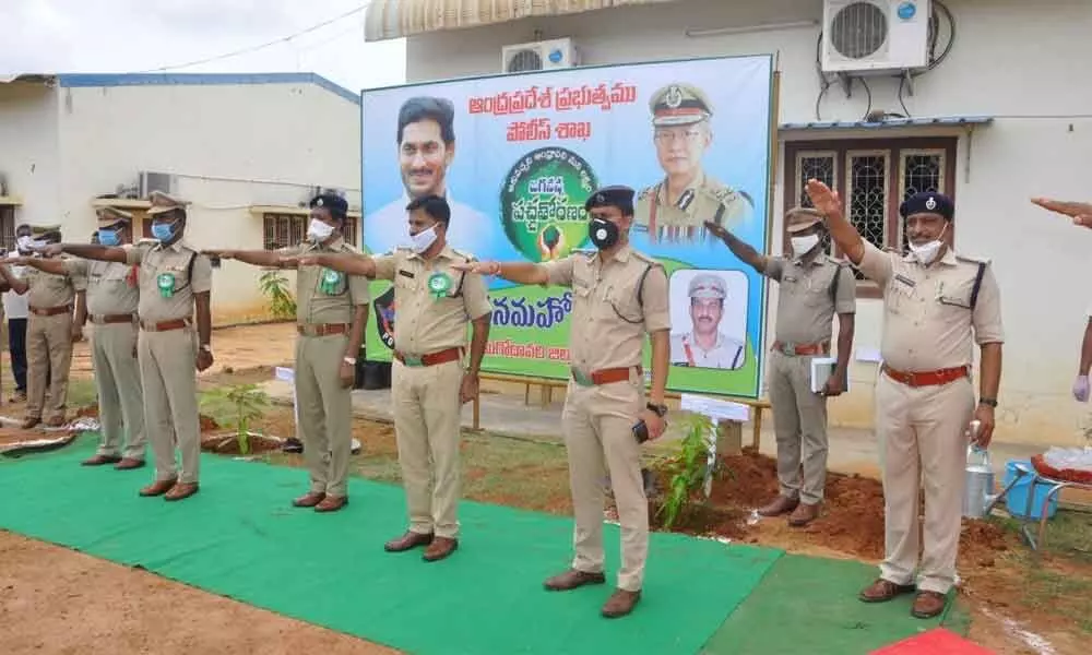 SP KN Narayan and others taking a pledge to protect planted saplings in Eluru on Wednesday