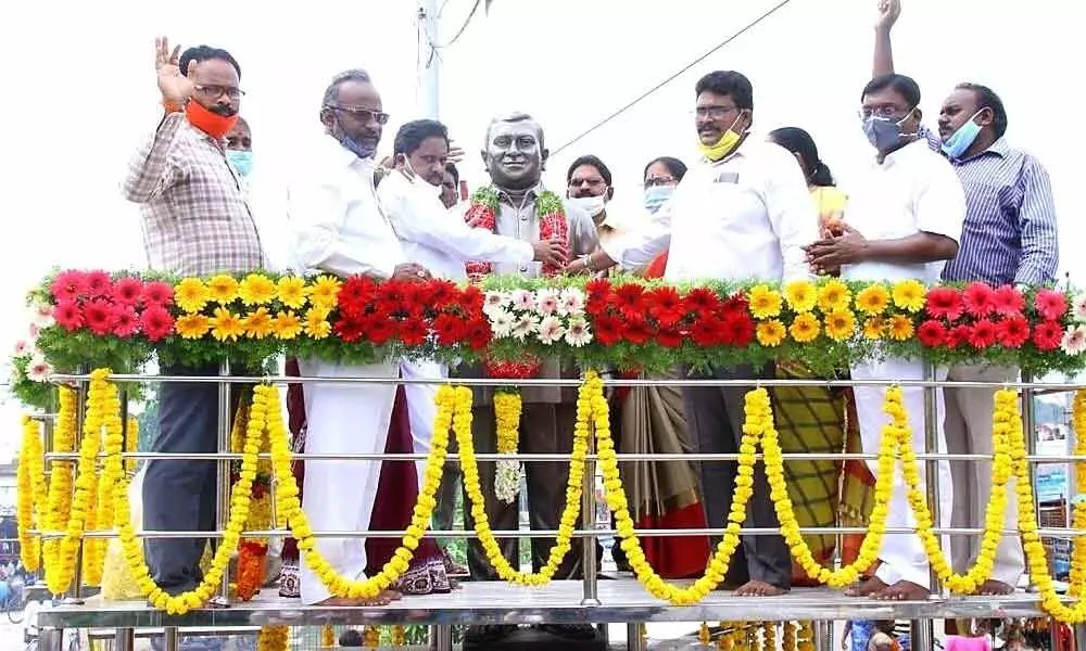 Family members, friends and fans paying rich tributes by garlanding the statue of GV Seshu in Ongole on Thursday