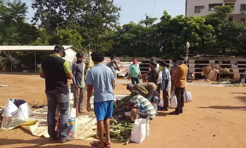 Consumers purchasing vegetables at Gandhinagar Rythu Bazaar in Kakinada on Monday