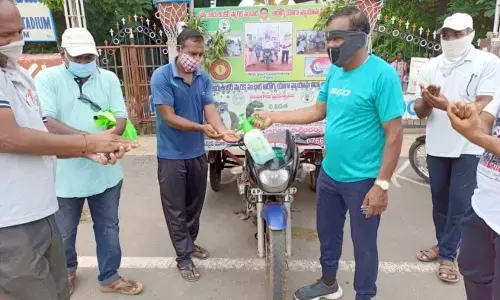 PET Matam Mallikarjun offering sanitiser to people in Khammam on Wednesday