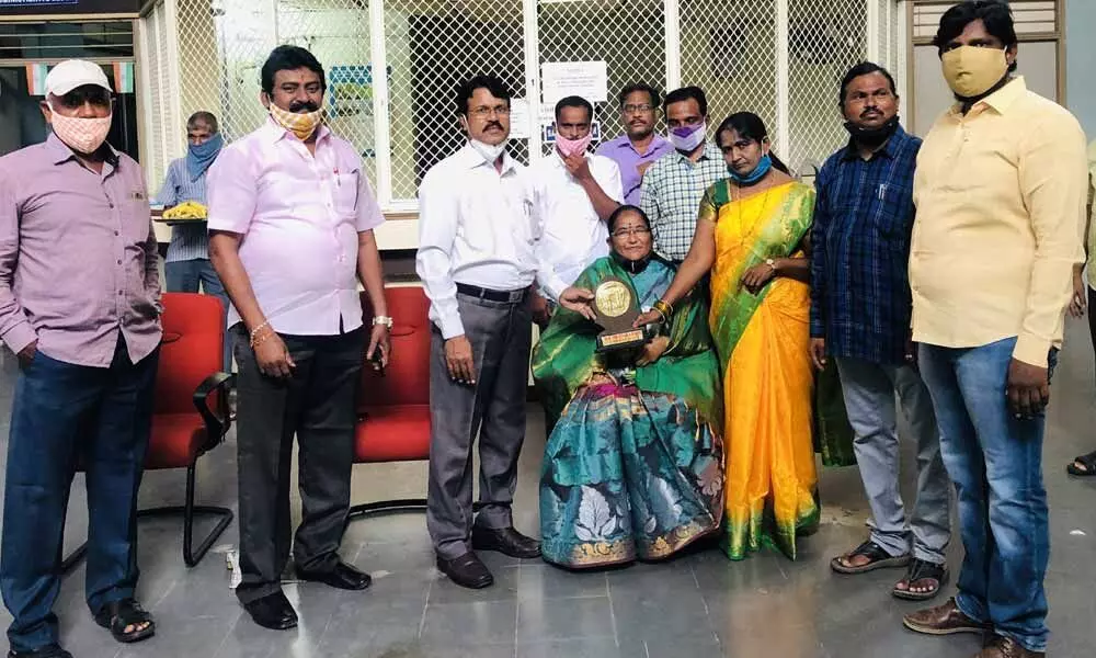 SDLCE Director Guguloth Veeranna felicitating an employee at Kakatiya University on Friday