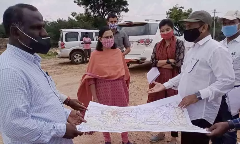 Engineers explaining the Basvapur reservoir Canal distribution system  to Collector Anitha Ramachandran  during her visit to project site on Saturday