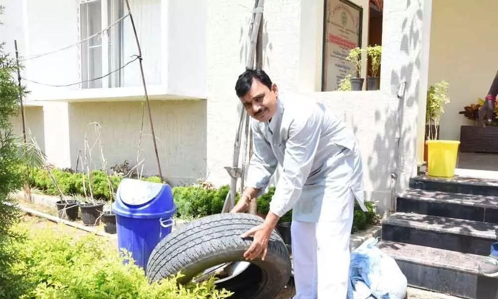 District Collector Dr A Sharath removing water stagnated in a tyre in his house in Kamareddy on Sunday