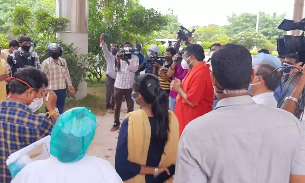 Relatives of Covid-19 patients expressing their concerns over poor amenities at VIMS to Tourism Minister M Srinivasa Rao