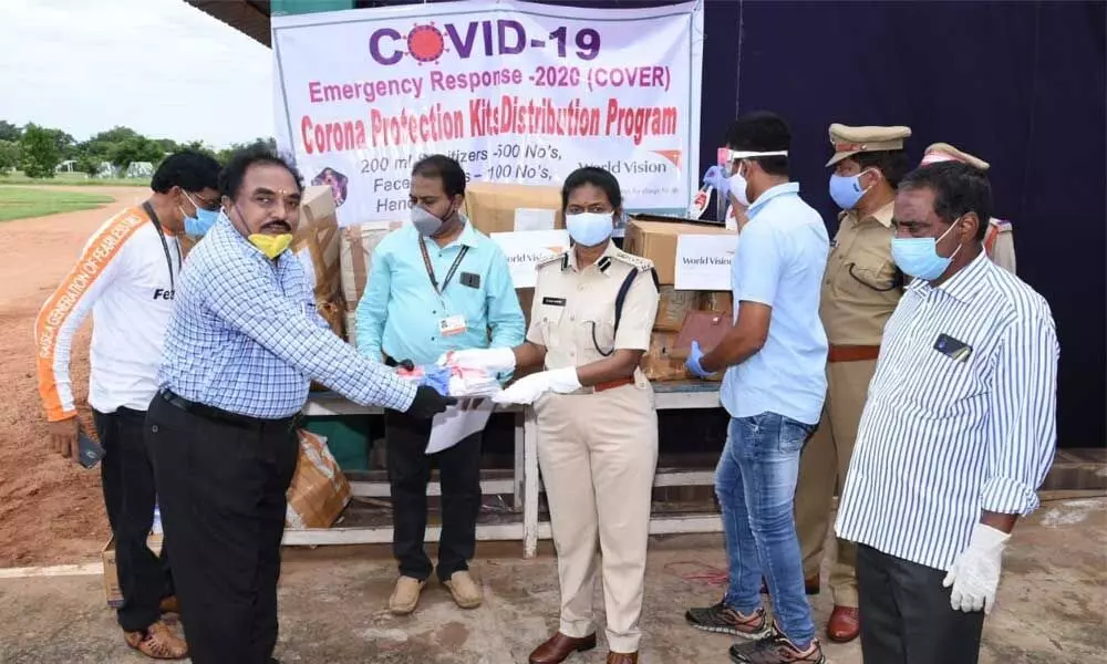 P Shyam Babu and K Apparao of World Vision handing over face shields, gloves and other material to SP B Rajakumari