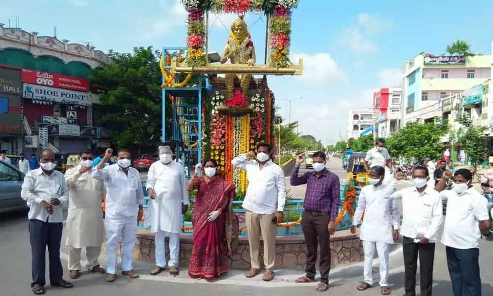 Municipal Chairperson J Kala, along with others, celebrating 6th National Handloom Day by garlanding the wearvers statue at old bus stand in Sircilla on Friday