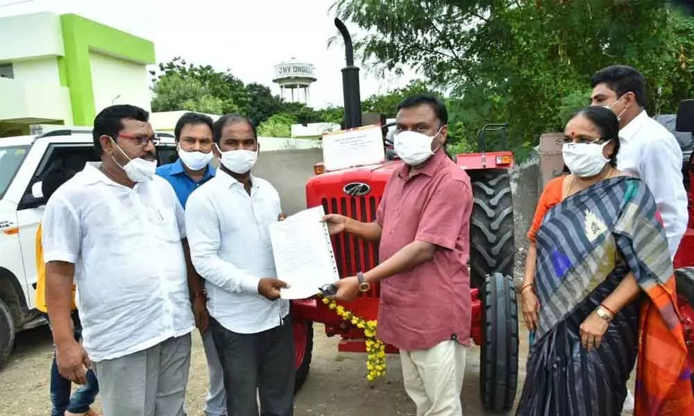 Prakasam Collector Dr Pola Bhaskara distributing a tractor to a tribal beneficiary on Sunday