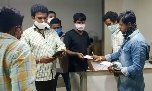 SMC revenue wing staff handing over a receipt on payment of penalty fee by an automobile spare parts shop owner