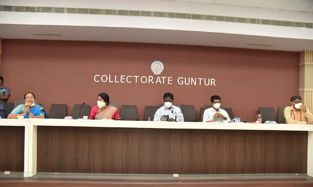 Collector I Samuel Anand Kumar addressing a review meeting in Guntur on Monday. Joint Collector A S Dinesh Kumar and GMC Commissioner Challa Anuradha are also seen.