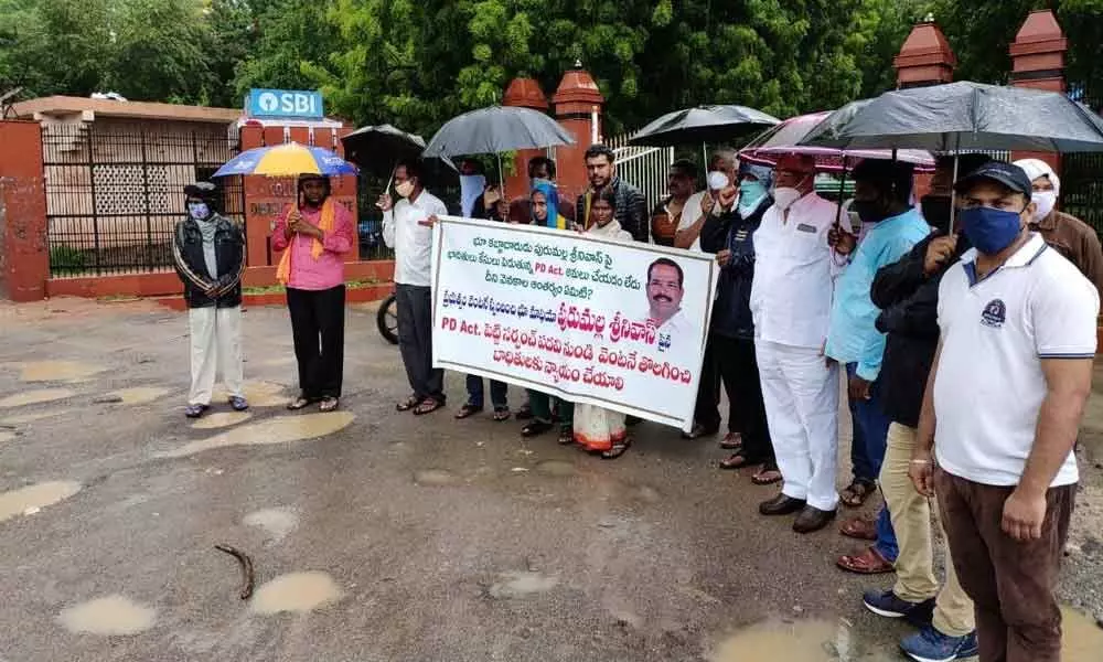 The land victims of Bommakal Sarpanch P Srinivas staging dharna in heavy rain in front of the Collectorate in Karimnagar district on Thursday