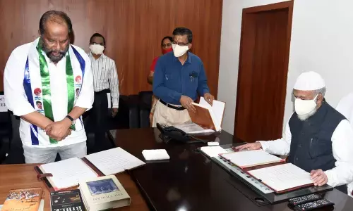 Legislative Council Chairman M A Shariff administering oath as MLC to P Ravindra Babu at Velagapudi on Friday