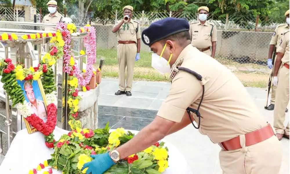 Urban SP A Ramesh Reddy placing a wreath at the portrait of AR SI Rajkumar, who died of Covid-19, in Tirupati on Sunday