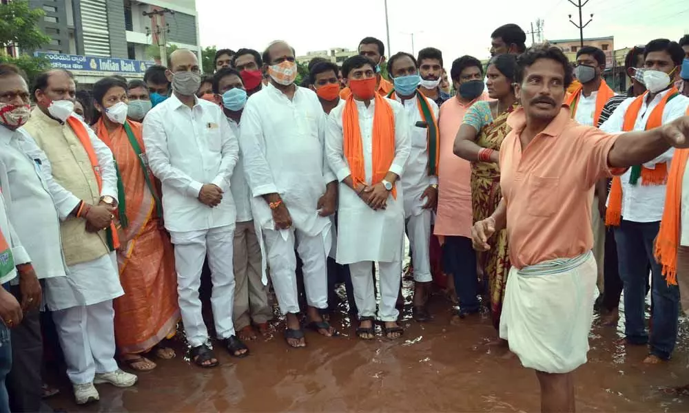 A resident explaining flood situation to BJP State President Bandi Sanjay