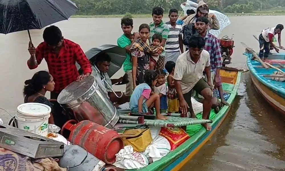 Tribals being taken to safer places in boats after their hamlets got marooned in Godavari floodwater