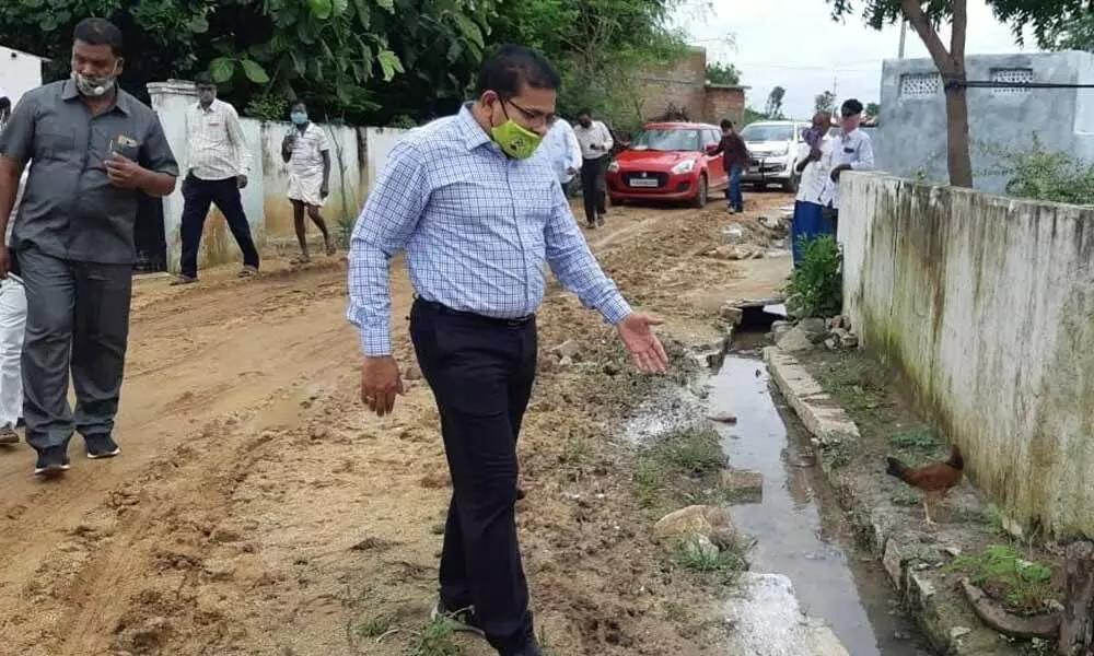 District Collector L Sharman Chavan inspecting a sewage canal in Khanapur village on Wednesday