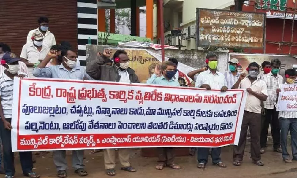 Workers staging dharna at Seetarampuram in Vijayawada on Thursday