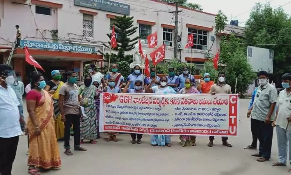 Government General Hospital sanitation workers staging a dharna at State Covid-19 Hospital in Kakinada on Monday