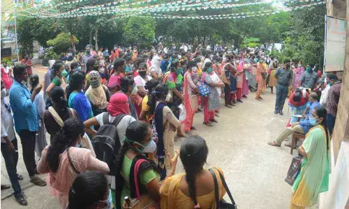 Candidates arrive at King George Hospital for certificate verification of staff nurse posts in Visakhapatnam on Tuesday. Social distancing went for a toss as the officials concerned turned a blind eye towards adherence to safety protocols. -Photo: A Pydiraju