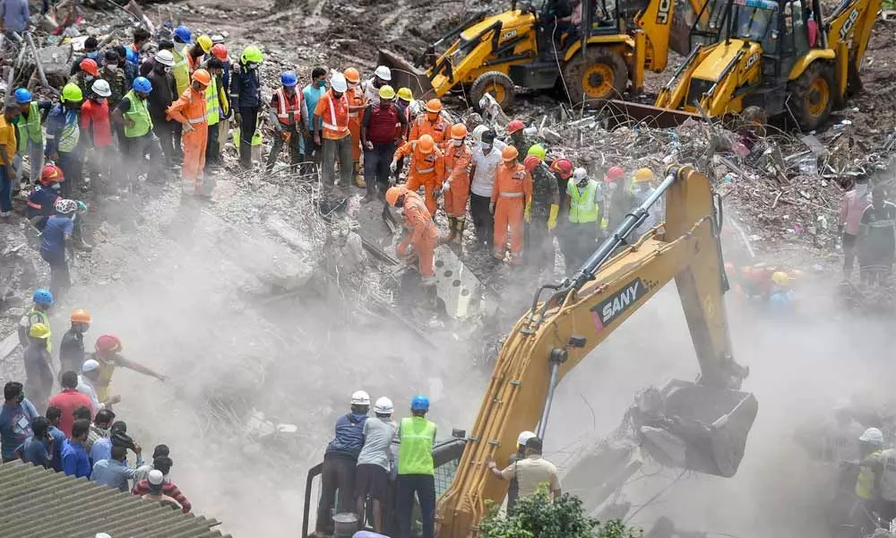 Rescue personnel sift through the rubble in search of survivors at the site where a five-storey apartment building collapsed