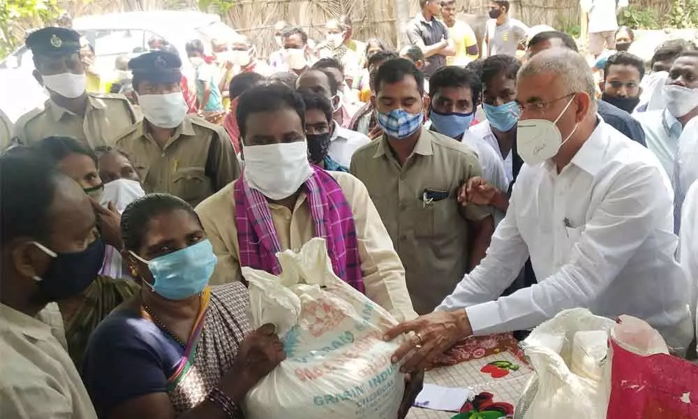 Minister CSVG Krishna distributing essential commodity kits to flood victims in K Gangavaram on Tuesday