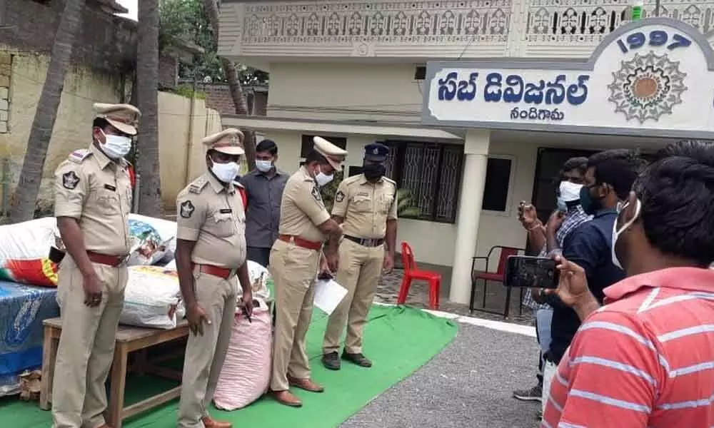 Police with seized gutka packets in Nandigama on Wednesday