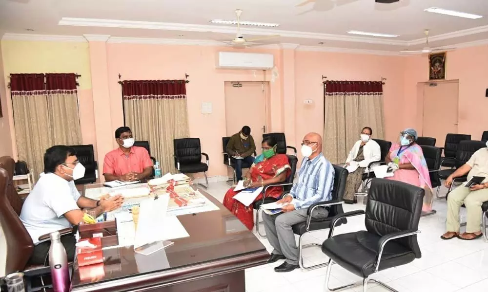 Collector K V N Chakradhara Babu interacting with the officials during a review meeting on the Covid-19 at the camp office in Nellore on Friday