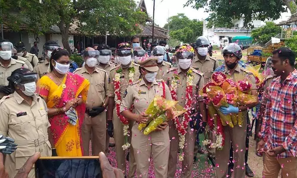 Kaikaluru police welcome their colleagues showering flowers on them following their recovery from Covid and rejoining of the duty (file photo)