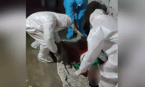 Sub-Inspector K V Ramarao and other police personnel taking the body of youth for last rites, in Jaggaiahpet