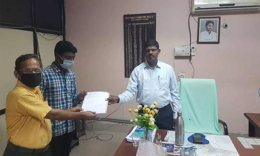 District Educational Officer S Abraham and Ravindra Bharati School Principal M Anjani Kumar handing over original degree and B Ed certificates to English teacher G Surendra Nath in Kakinada on Tuesday