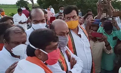 BJP State President Bandi Sanjay Kumar inspecting double bedroom houses in Harichandrapuram village on Thursday