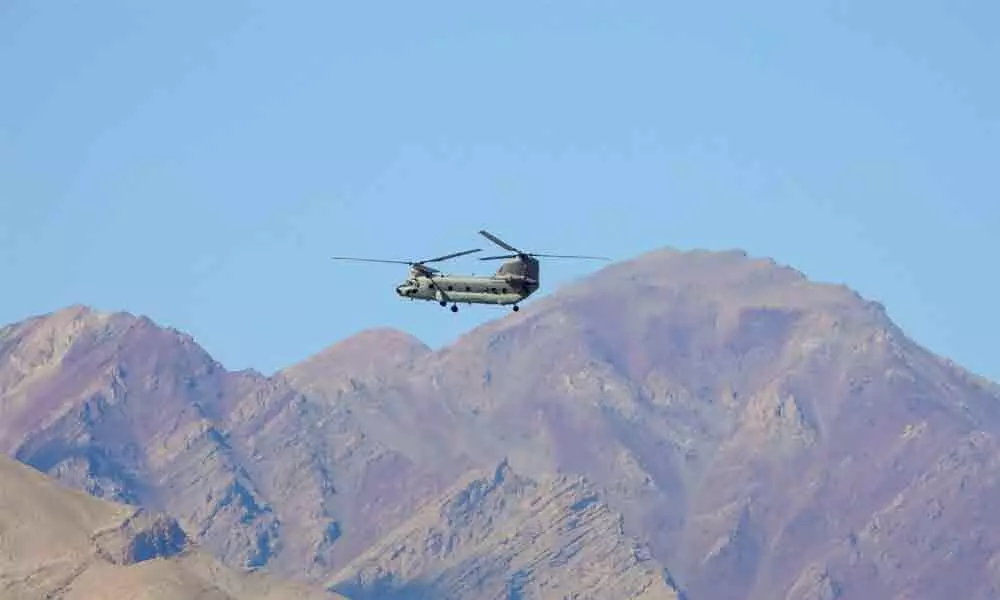 IAF Chinook helicopter flies amid the prolonged India-China stand off in the Ladakh region, in Leh on Thursday