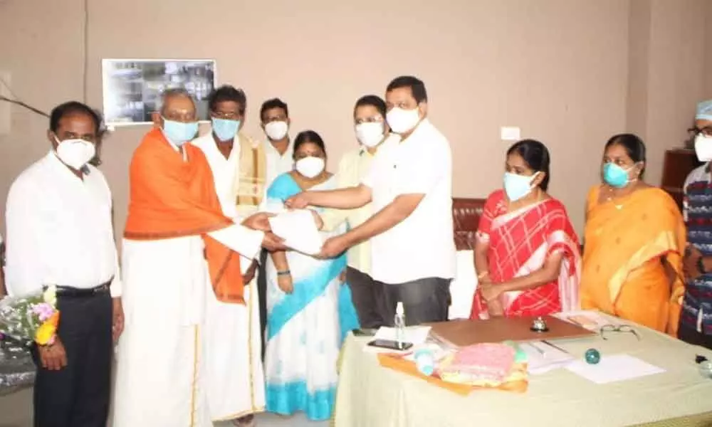 TUDA vice-chairman S Hari Krishna giving away discharge summaries to two 80-year old Covid patients in Tirupati on Friday