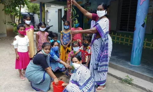 Anganwadi staff planting a sapling at APJ Abdul Kalam High School in Arundelpet