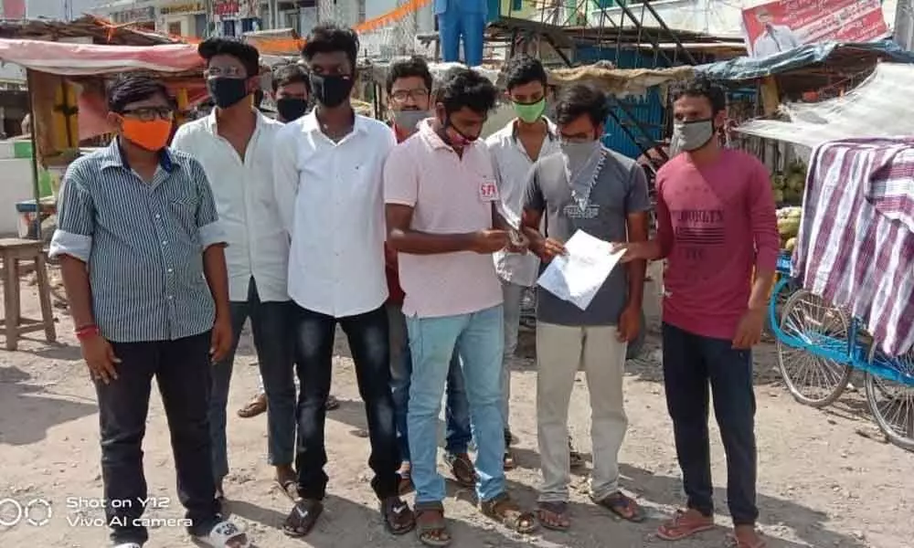 SFI activists burning ANU degree examinations timetable in Piduguralla on Sunday