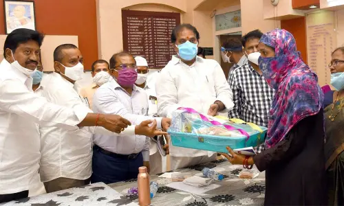 Endowments Minister Vellampalli Srinivas, Collector Md Imtiaz and others handing over the YSR Sampoorna Poshana kit to a beneficiary in Vijayawada on Monday