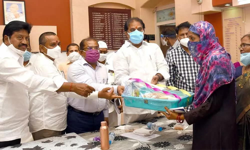 Endowments Minister Vellampalli Srinivas, Collector Md Imtiaz and others handing over the YSR Sampoorna Poshana kit to a beneficiary in Vijayawada on Monday