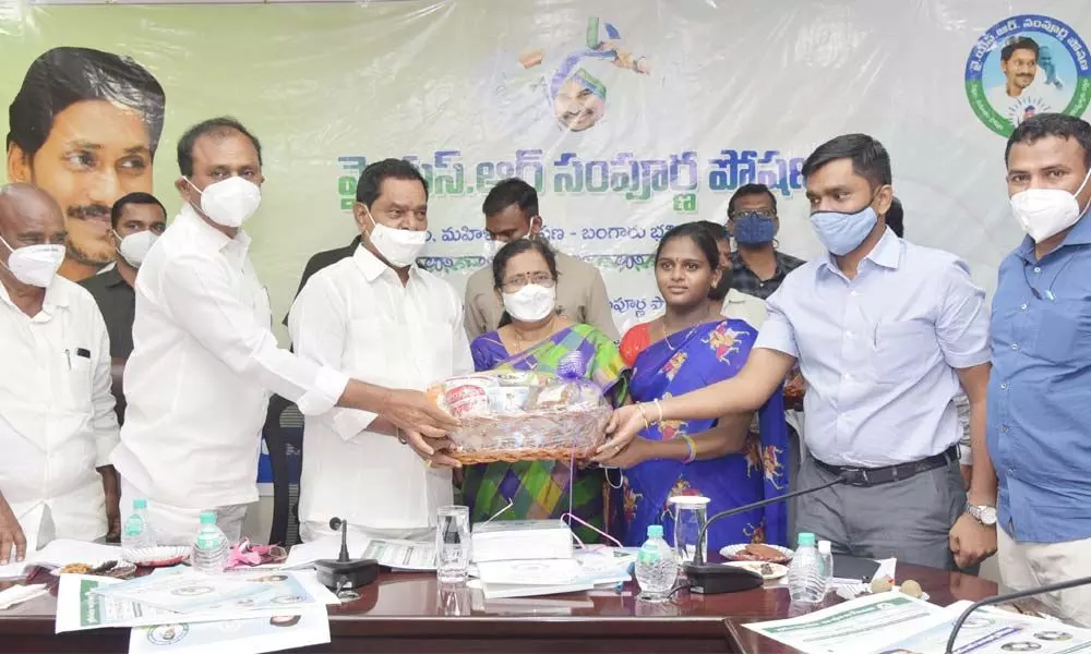 Deputy Chief Minister K Narayana Swamy distributing YSR Sampoorna Poshana scheme benefits to beneficiaries at the Municipal Office in Tirupati on Monday