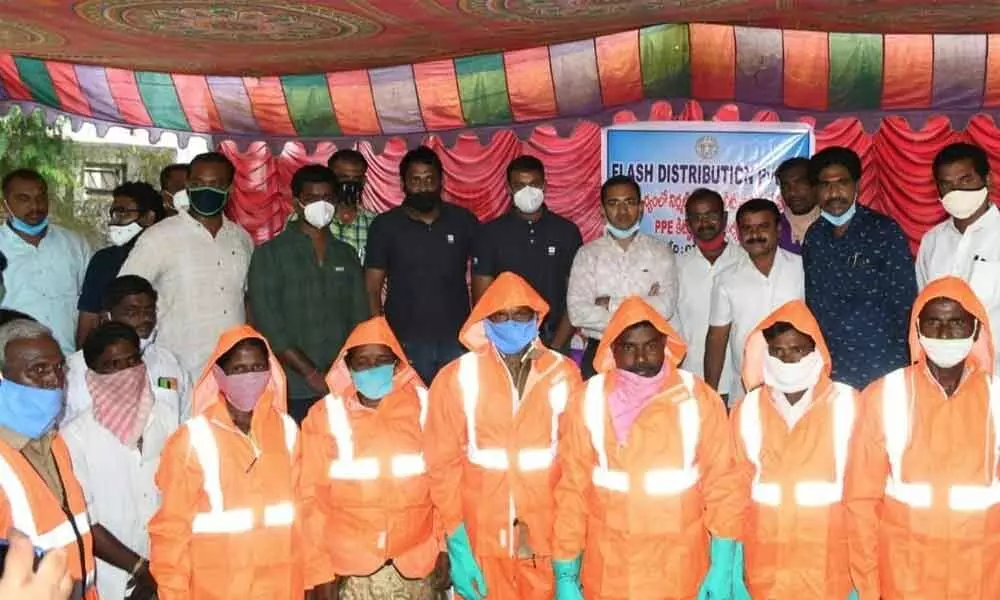District Collector Musharraf Ali Farooqui with the sanitation workers after distributing PPE kits to them at municipal office in Nirmal town on Monday