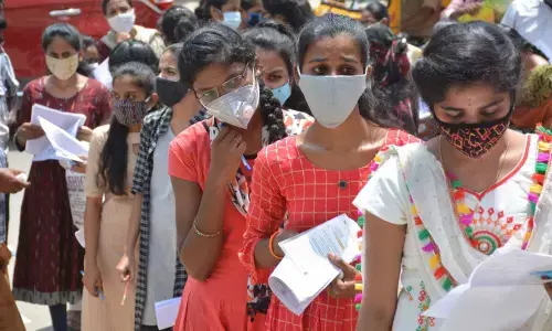 Students appearing for their first EAMCET examination standing at the entrance of an exam centre with all safety precautions for the Covid-19 pandemic in Hyderabad on Wednesday	Photo: Ch Prabhu Das