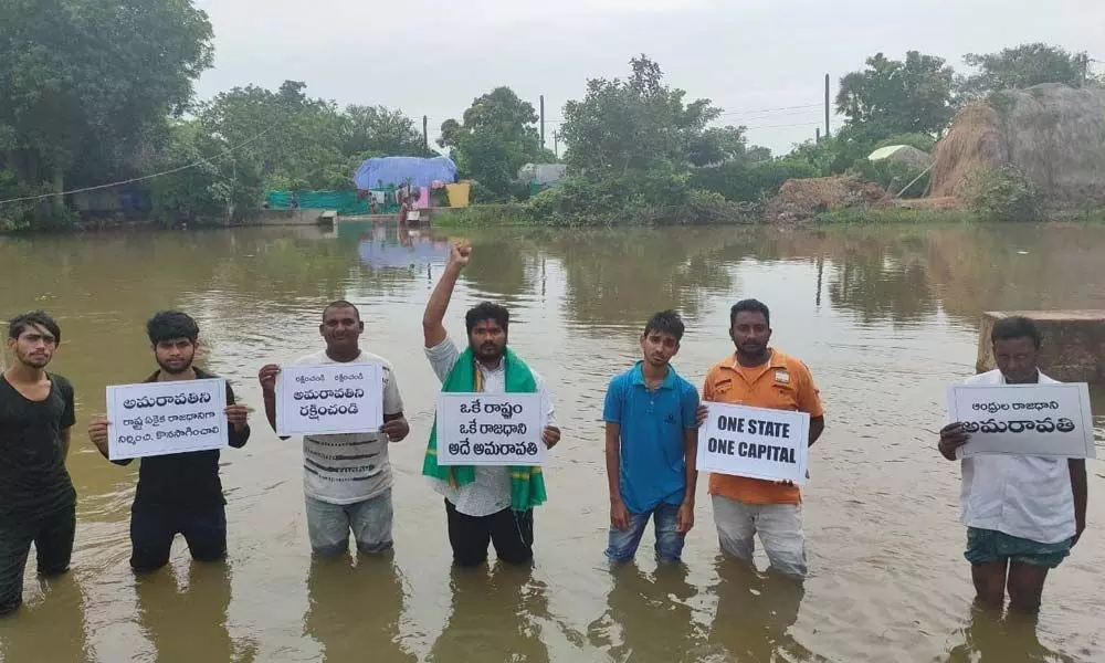 Youth staging a protest in River Krishna at Penamakuru in Krishna district on Saturday demanding that the government continue the State capital in Amaravati