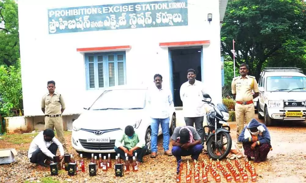 Circle Inspector Rajasekhar Goud along with his team producing the seized liquor at the excise office in Kurnool on Sunday