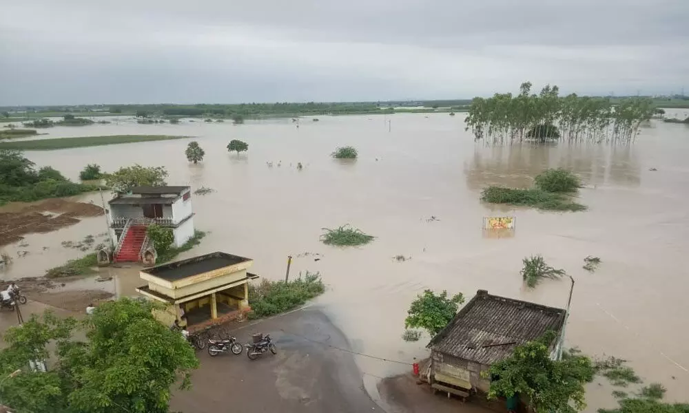 Pedavagu stream floodwater entering Amaravati-Vijayawada road at Pedmaddur in Guntur district on Tuesday