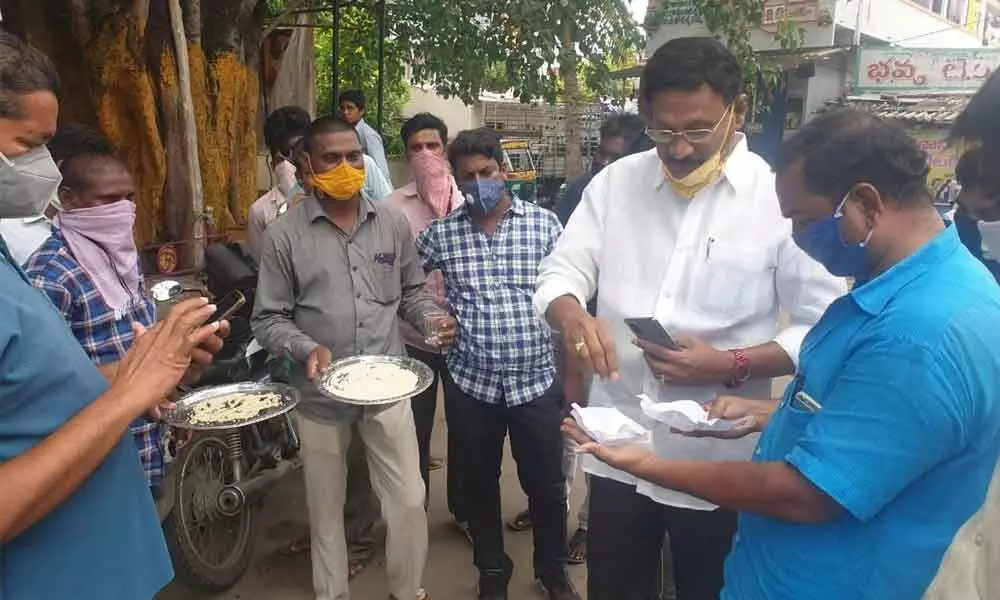 MLA Gadde Rammohan explaining about the midday meals rice to residents of Dr BR Ambedkar Nagar