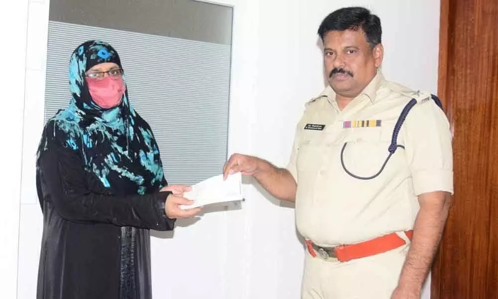 SP M Ravindranath Babu handing over cheque to the kin of a cop in Machilipatnam on Thursday