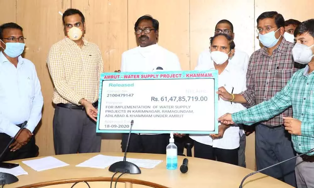 Transport Minister P Ajay Kumar handing over a cheque to L&T Project Manager Hari Prasad in Khammam on Friday