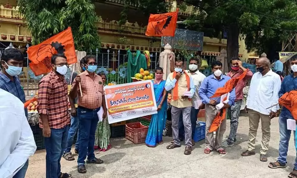 BMS representatives distributing pamphlets to people appealing them to purchase items from street vendors in Karimnagar on Friday