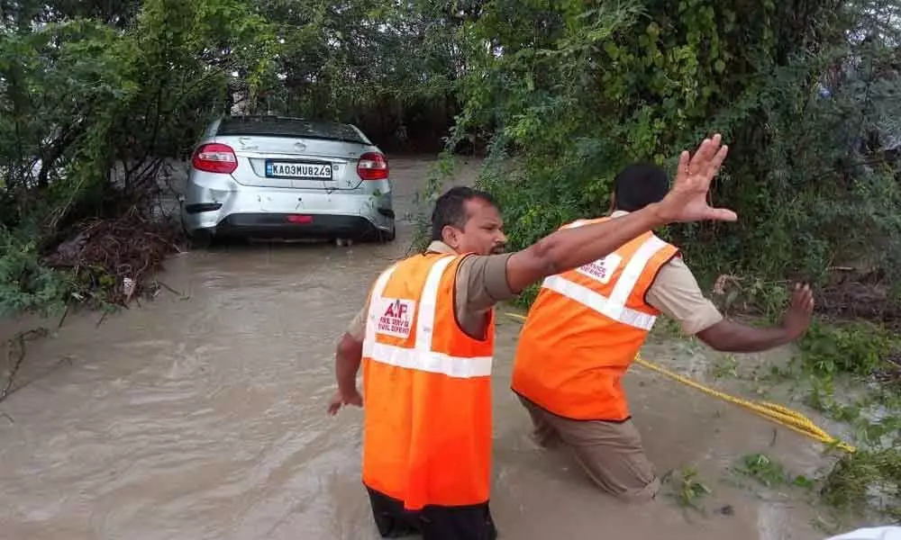 Rescue team personnel rescuing two persons trapped in a car in Aligi lake.