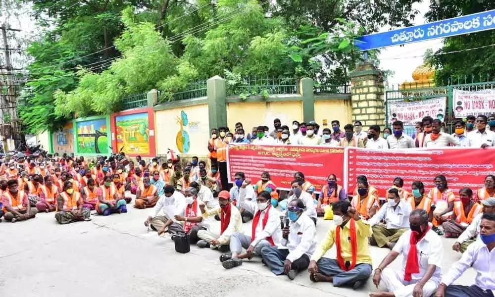 Contract civic workers staging a dharna at corporation office in Chittoor on Monday