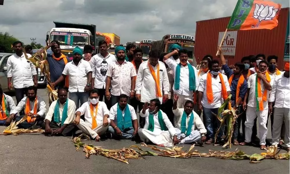 BJP Kisna Morcha leaders and farmers staging a rasta roko on NH 44 on the suburbs of Armoor on Thursday